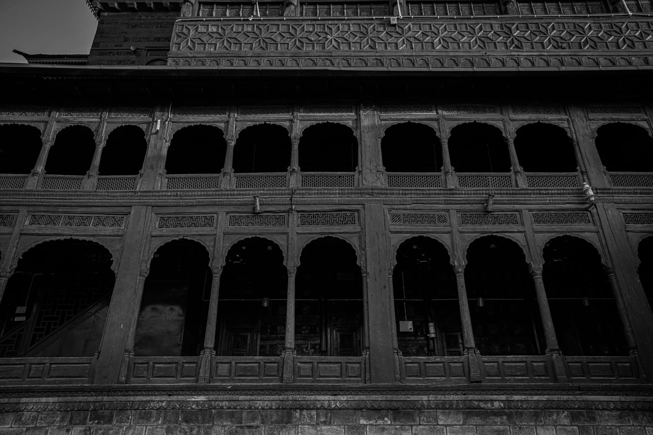 Black and white view of historic arched facade showcasing architectural elegance.
